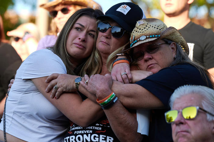 Lauren Reh, Alicia Mierke and Sue Ann Cornwell embrace during the Sunrise Remembrance ceremony at Clark County Government Center Amphitheater in Las Vegas on Oct. 1, 2022.