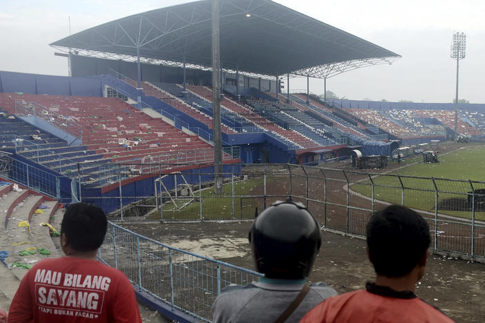 People examine the damage following a soccer match stampede at the Kanjuruhan Stadium in Malang, East Java, Indonesia.