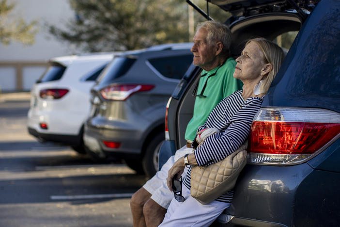 Jim and Susan Helton sit int he back of a car outside a hotel in Fort Myers, Fla. Their home in Fort Myers beach was destroyed by Hurricane Ian.