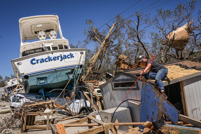 People clear debris in the aftermath of Hurricane Ian in Fort Myers Beach, Florida, on Friday.