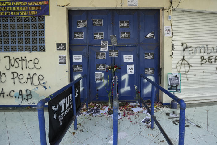 Protest signs cover a gate at the Kanjuruhan Stadium in Malang, Indonesia on Tuesday. Police said the gates at the soccer stadium could only accommodate two people at a time when hundreds were trying to escape.