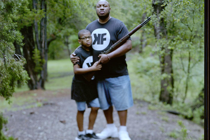 Aaron Banks, 38, and his son Aaron Banks, Jr., 8, embrace at a local park on Saturday, May 22, 2021, in Cedar Park, Texas. "The image of the average gun enthusiast needs an update," the elder Banks said. Banks is president of Keep Firing LLC and one of 24 pistol instructors certified by the National African American Gun Association.