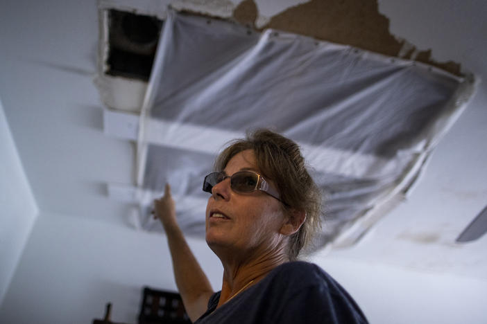 Alva Sulaty points to the damage in her home in North Port, Fla., on Wednesday, after Hurricane Ian flooded her neighborhood.