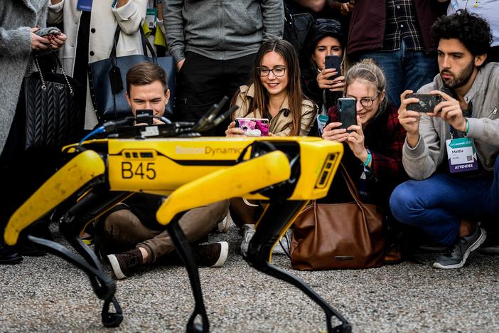 People take pictures and videos of the Boston Dynamics robot Spot during an event in Lisbon in 2019.