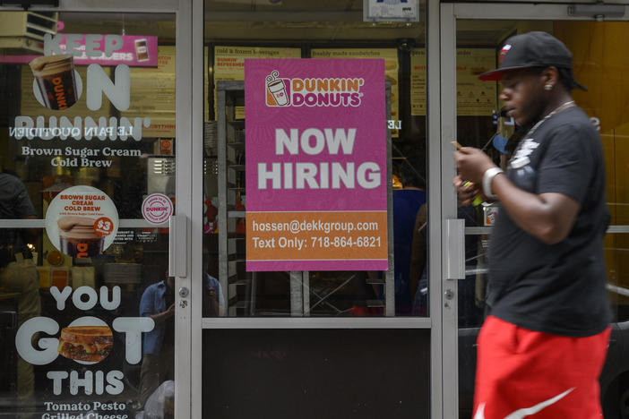 A man walks past a "Now Hiring" sign in New York City on July 8, 2022. Signs that job growth cooled in September could help with uncomfortably high inflation.