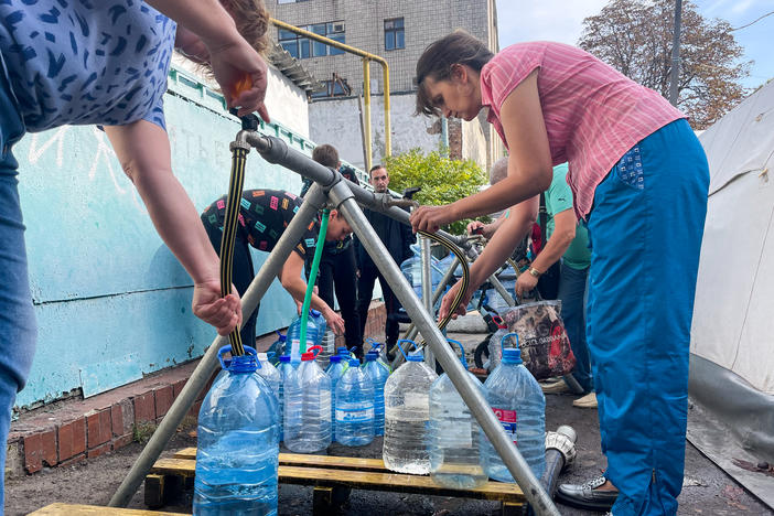 Residents of Mykolaiv collect clean water from a distribution station set up by the International Committee of the Red Cross on Oct. 1.