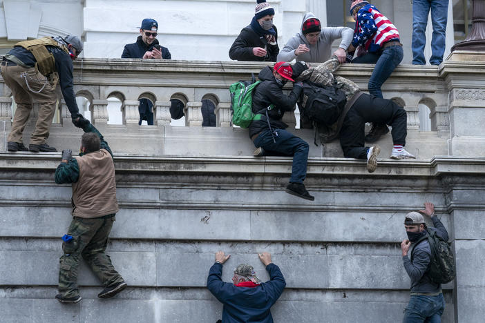 Insurrectionists climb the west wall of the the U.S. Capitol, Jan. 6, 2021, in Washington.