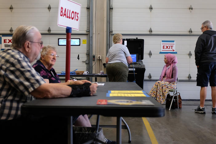 Poll workers and voters are seen during Wisconsin's state primary on Aug. 9. While experts say the overwhelming majority of American poll workers are dedicated to a fair and secure election, some officials are worried about poll worker interference.