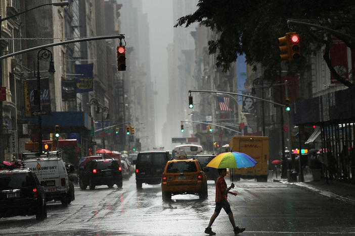 A man walks through the rain during an intense afternoon thunderstorm in 2012 in New York City.