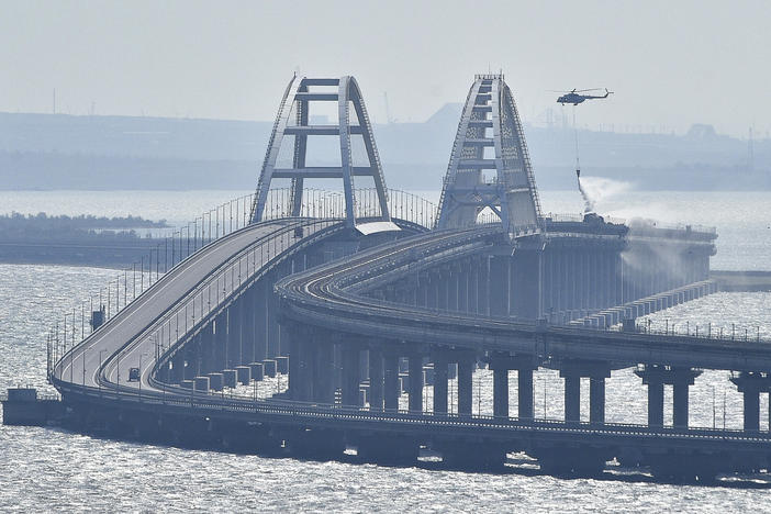 A helicopter drops water to stop fire on Crimean Bridge connecting the Russian mainland and Crimean peninsula over the Kerch Strait on Saturday.