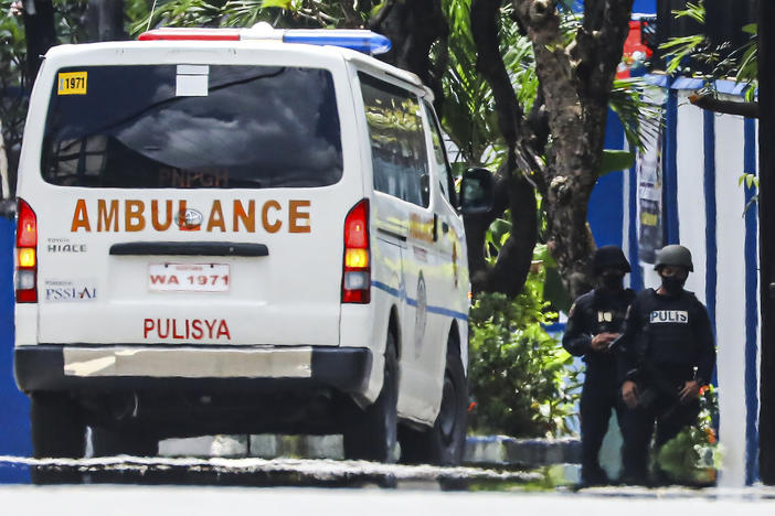 Police keep watch as an ambulance is parked outside the PNP Custodial Compound in Camp Crame police headquarters, Metro Manila, Philippines on Sunday Oct. 9, 2022.