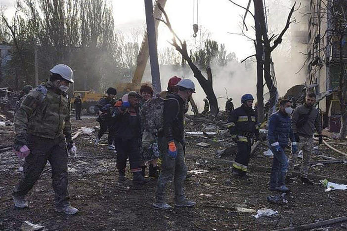 In this photo provided by the Ukrainian Emergency Service, rescuers work at the scene of a building damaged by shelling in Zaporizhzhia, Ukraine, Sunday, Oct. 9, 2022.