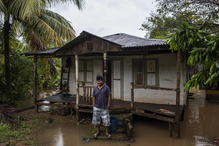 A man stands outside his house surrounded by floodwaters after Hurricane Julia swept through the area in Bluefields, Nicaragua, on Sunday. The storm hit Nicaragua's central Caribbean coast and dumped torrential rains across Central America before reemerging over the Pacific as a tropical storm.