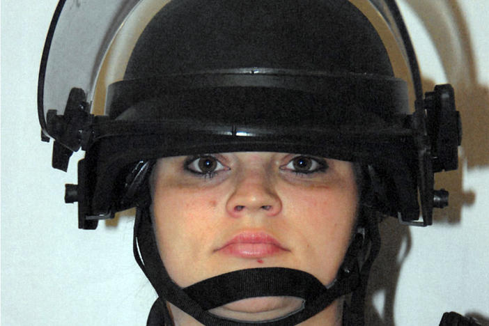 Former Louisville Metro Police officer Katie R. Crews, show in riot gear, pleaded guilty on Tuesday to a federal charge of using excessive force during curfew enforcement the night of David McAtee's death.