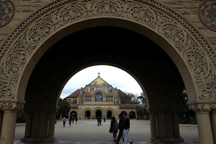 Students and visitors walk on Stanford University's campus in 2019.