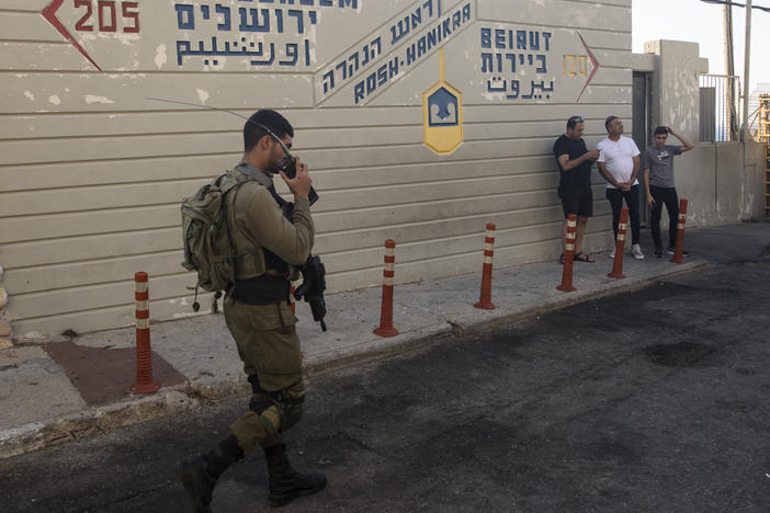 An Israeli soldier walks past a sign at a tourist site at the Israeli side of the border with Lebanon in Rosh Hanikra, Israel, on Tuesday.