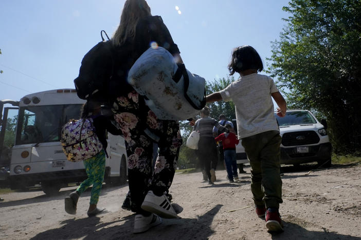 A migrant family from Venezuela walks to a Border Patrol transport vehicle after they and other migrants crossed the U.S.-Mexico border and turned themselves in June 16, 2021, in Del Rio, Texas.