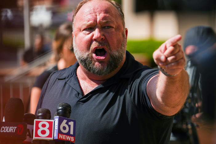 InfoWars founder Alex Jones speaks to the media outside Waterbury Superior Court during his trial last month in Waterbury, Conn.