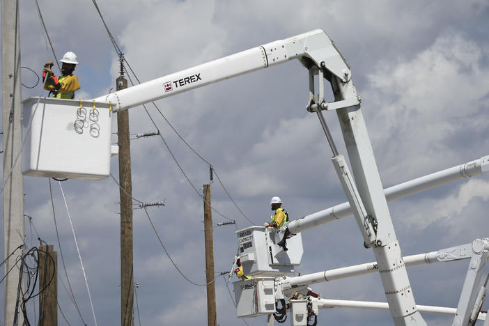 Power crews work to restore electricity in the wake of Hurricane Ian on Oct. 6 on San Carlos Island, in Florida's Lee County.