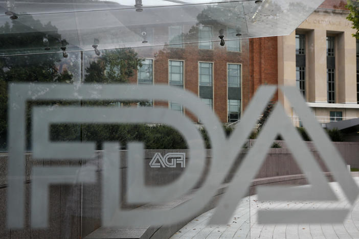 In this Aug. 2, 2018, file photo, the U.S. Food and Drug Administration (FDA) building is visible behind FDA logos at a bus stop on the agency's campus in Silver Spring, Md.