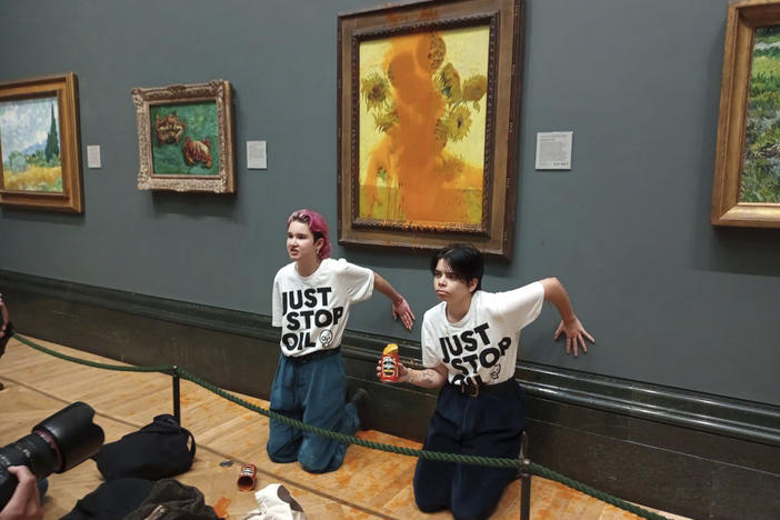 A handout photo issued by the group Just Stop Oil shows two protesters who threw soup at Vincent Van Gogh's famous 1888 work <em>Sunflowers</em> at the National Gallery in London on Friday.