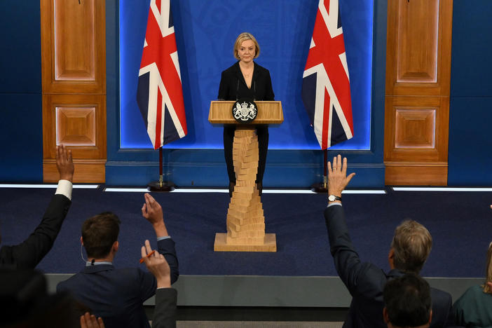 Journalists raise their hands for questions as Britain's Prime Minister Liz Truss holds a news conference in the Downing Street Briefing Room in central London, Friday. Truss let go her finance chief Kwasi Kwarteng and reversed course on sweeping tax cuts.