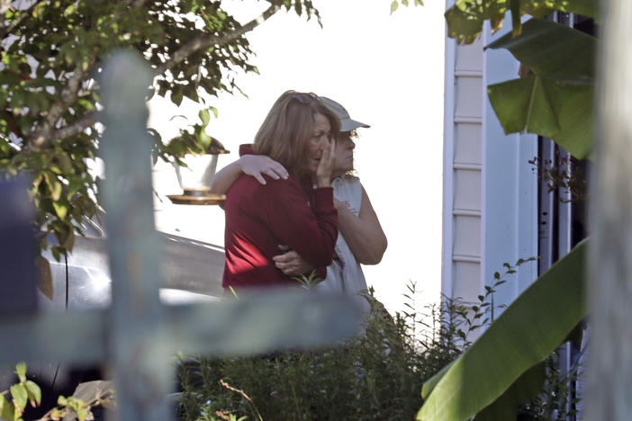 Neighbors embrace on Friday as police continue to investigate  the scene of a shooting that occurred Thursday night in Raleigh, N.C.