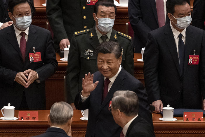 Chinese President Xi Jinping (center) waves to senior members of the government as he leaves at the end of the opening ceremony of the 20th National Congress of the Communist Party of China at The Great Hall of People in Beijing on Sunday.