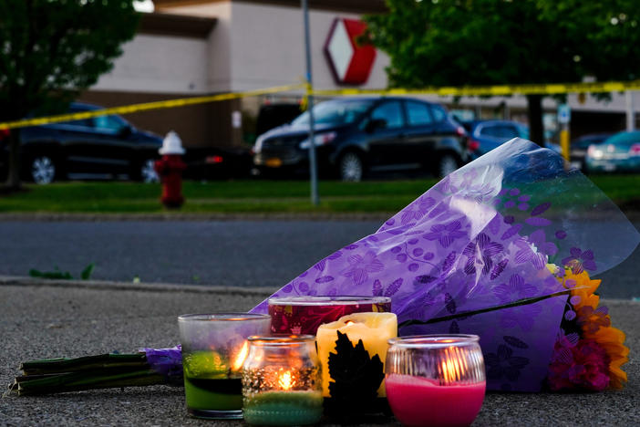 Flowers and candles lay outside the scene of a shooting at a supermarket, in Buffalo, N.Y., Sunday, May 15, 2022.