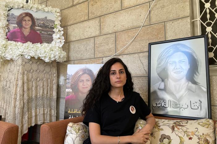 Lina Abu Akleh sits near photographs of her late aunt, journalist Shireen Abu Akleh, at their family home in east Jerusalem in July.