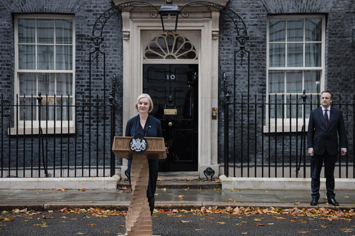 Prime Minister Liz Truss delivers her resignation speech as her husband, Hugh O'Leary, stands nearby at Downing Street in London on Thursday. Truss has been prime minister for just 44 days.
