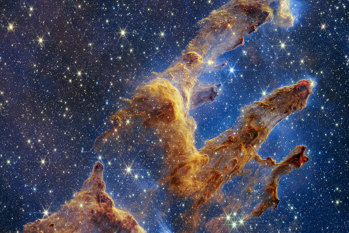 The Pillars of Creation as captured by NASA's James Webb Space Telescope look like arches and spires and are filled with semi-transparent gas and dust. This is a region where young stars are forming.