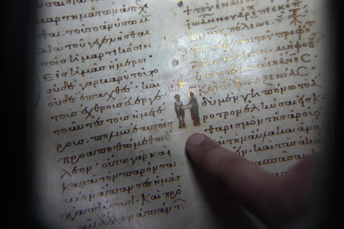 Father Theofilos, a Pantokrator monk, shows a manuscript at the library of Pantokrator Monastery in the Mount Athos, northern Greece, on Thursday, Oct. 13, 2022.