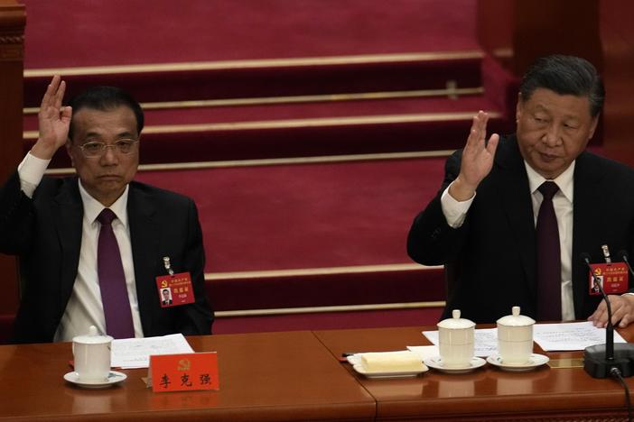 Chinese President Xi Jinping, right, looks over as Chinese Premier Li Keqiang raises his hand to vote at the closing ceremony of the 20th National Congress of China's ruling Communist Party in Beijing on Saturday.