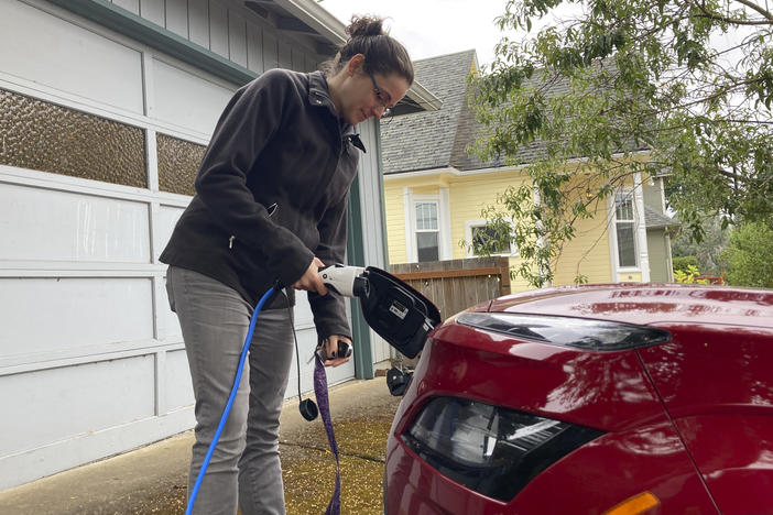 Rebecca DeWhitt charges her electric vehicle in the driveway of the Portland, Ore., home she rents on Sept. 30.