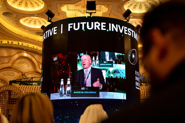 Attendees watch David Solomon, chief executive officer of Goldman Sachs & Co., on a screen as he speaks during a panel session at the Future Investment Initiative (FII) conference in Riyadh, Saudi Arabia, on Tuesday, Oct. 25, 2022.