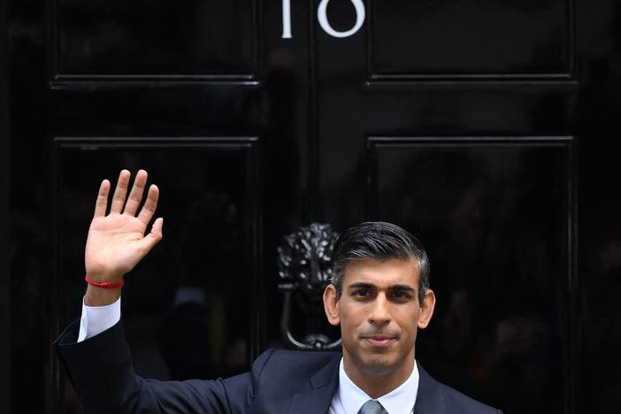 Rishi Sunak waves outside to door to No. 10 Downing Street on Tuesday after delivering his first speech as prime minister.