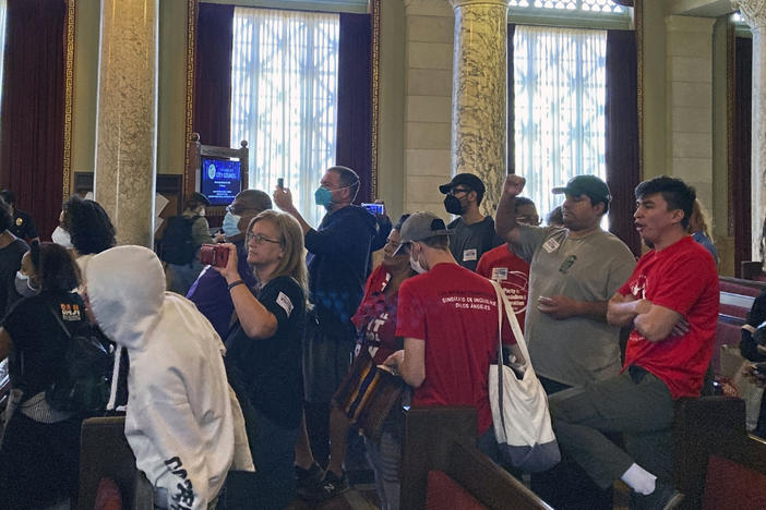 Protesters walk away after disrupting a Los Angeles City Council meeting demanding the resignations of council members, Kevin de Leon and Gil Cedillo in Los Angeles, Wednesday, Oct. 26, 2022.