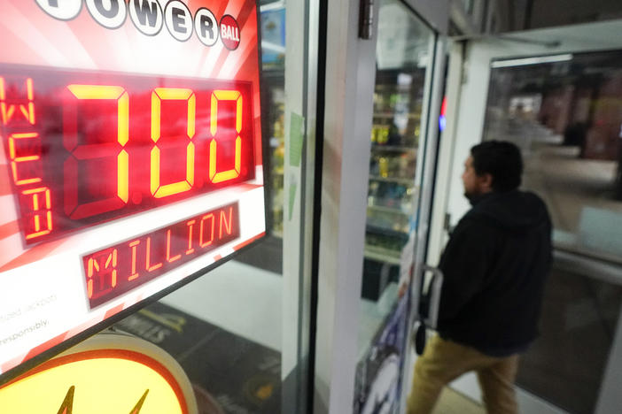 A patron enters a liquor store as a sign displays the Powerball jackpot, Tuesday, Oct. 25, 2022, in Baltimore.