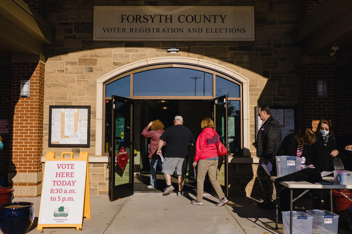 People walk into a polling location at the Elections and Voter Registration Office in Cumming, Ga.