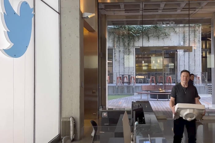 This image from the Twitter page of Elon Musk shows Musk entering Twitter headquarters carrying a sink through the lobby area on Wednesday, Oct. 26, 2022 in San Francisco. Musk posted a video Wednesday showing him strolling into Twitter headquarters ahead of a Friday deadline to close his $44 billion deal to buy the company.