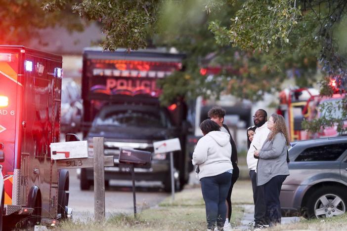 People look on as Broken Arrow, Okla., police and fire department investigate the scene of a fire with multiple fatalities at the corner South Hickory Ave. and West Galveston St. on Thursday, Oct. 27, 2022.