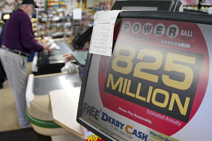 Dave Colbert pays for his groceries at a market in Prospect, Pa., on Friday before buying a ticket for Saturday's Powerball drawing.