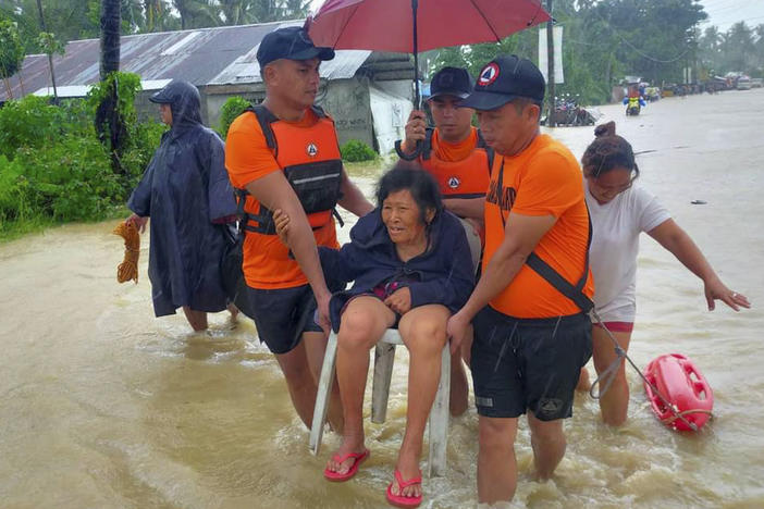 Rescuers evacuate residents from flood waters caused by Tropical Storm Nalgae in Hilongos, Leyte province, Philippines on Friday.