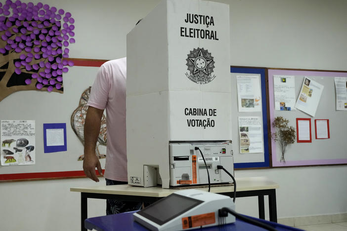 An electoral worker installs an electronic voting machine at a polling station in preparation for the presidential run-off election, in Brasilia, Brazil, Saturday, Oct. 29, 2022.