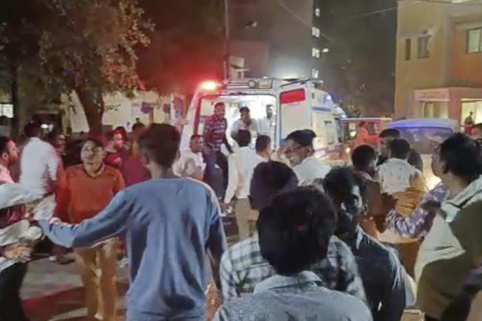 This image from video shows the commotion outside a hospital where victims of a cable bridge collapse were being rushed in for treatment Sunday in Morbi district, western Gujarat state, India.
