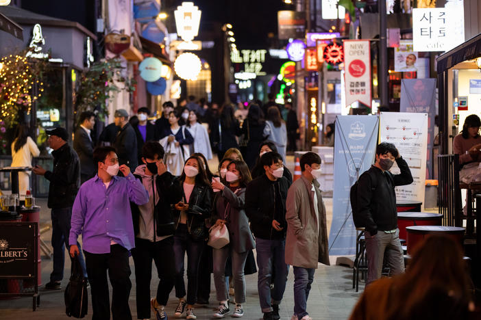 People wearing protective face masks walk through the Itaewon district in Seoul, South Korea, on Friday, April 24, 2020. South Korea reported six more coronavirus cases for the past 24 hours on Friday. New cases have slowed from a daily peak of more than 900 in late February. Photographer: