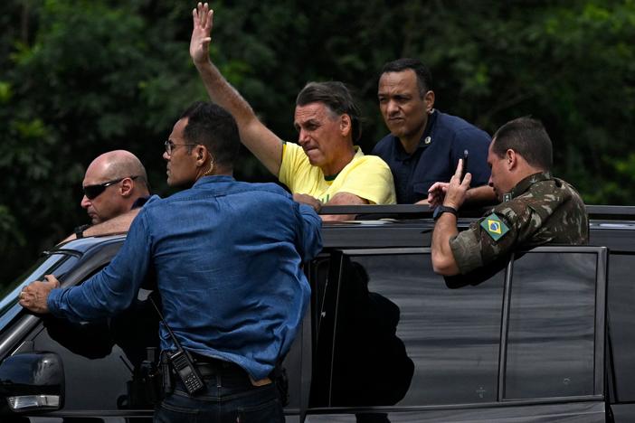 Brazilian President Jair Bolsonaro waves at supporters after voting in the presidential runoff election, on his way to Galeao airport in Rio de Janeiro on Sunday.