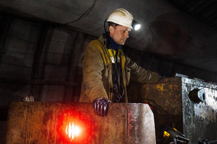 A mine railway operator in Eastern Ukraine waits as workers disembark. Russia's invasion of Ukraine disrupted global supplies of fossil fuels and led to more reliance on coal for electricity in some countries. The future sources of energy around the world are major topics at climate negotiations underway in Egypt starting this week.