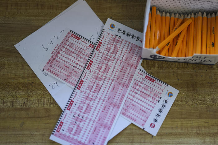 Two Powerball playslips sit on top of a piece of scratch paper at Bluebird Liquor in Hawthorne, Calif., Wednesday, Nov. 2, 2022.